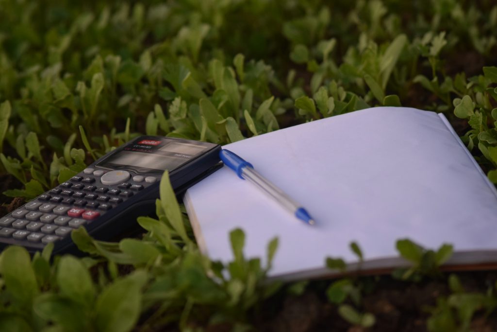 a calculator and pen for managing budgets